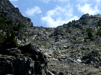scree slope to col around buttress and up to left. Note yellow/black markers.