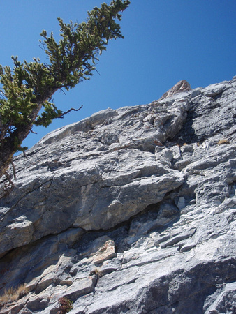 Big second rock band 50 mSlants up to right. Lots of cairns. Go down and left to find layback crack.